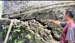 Seorang warga menunjukan rumahnya yang retak akibat pergerakan tanah (ist) 
