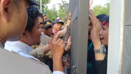 Anggota Dewan dari Fraksi PKS Rahmat Juliadi di dampingi aparat dari Polres Sumedang saat berbicara dengan salah seorang pendemo di pagar besi kantor DPRD Kabupaten Sumedang. 