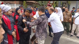 Ketua KPU Sumedang, Ogi Ahmad Fauzi menyelendangkan kain batik kepada Cabup dan Cawabup Sumedang, Irwansyah Putra dan  Mustika Ningrat, saat melakukan pendaftaran ke kantor KPU Sumedang. 