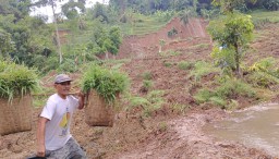 Salah seorang warga melintas di depan tebing setinggi 100 meter yang terjadi di 
Blok Lamping Dangder, Lingkungan Cilipung, Kelurahan Pasanggrahan Baru, Kecamatan Sumedang Selatan, Kabupaten Sumedang,  Minggu (1/12/2024) 

