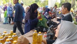 Salah seorang warga saat membeli minyak yang di selenggarakan Dinas  Pertanian dan Ketahanan Pangan Kabupaten Sumedang bekerja dengan dinas Ketahanan Pangan dan Peternakan Povinsi Jawa Barat. Kamis (19/12/2024). 

