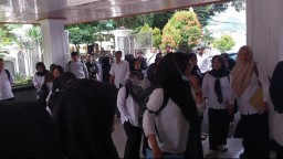 Dengan menggunakan pita hitam di lengan baju, salah seorang Calon P3K yang lulus tahun 2024,  saat akan memasuki Gedung DPRD Sumedang. Rabu (12/3/2025). 
