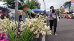 Salah seorang ibu saat melintasi jajaran pedagang bunga  di taman endog, Sumedang. Minggu (30/3/2025) 
