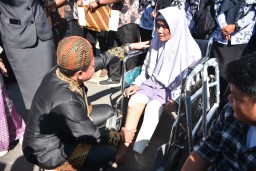 Bupati Sumedang Dony ahmad munir saat berbincang dengan salah seorang warga penerima bantuan kaki palsu. jum'at (2/5/2025) 
