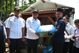 Bupati Sumedang, Dony Ahmad Munir Saat menyerahkan bantuan bibit ikan gurame. (Foto humas pemda sumedang)
