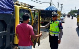 Salah seorang anggota Satlantas Polres Kendal, AKP Andi, saat memberikan himbauan kepada sopir truk yang memakirkan kendaraanya di bahu jalan Lingkar Kaliwungu, Jumat 12/05/2023. (Jateng Memanggil/Ist)