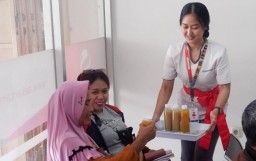Salah seorang petugas dari BPR Sekartama Weleri, Kendal, saat membagikan jamu dalam kemasan botol, kepada Customer, di ruang tunggu Kantor Cabang Sekartama Weleri, Kendal, Sabtu 27/05/2023. (Jateng Memanggil/Ist)