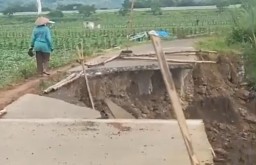 Keterangan: Kondisi saat ini jalan rapat beton di Desa Kertomulyo, Brangsong yang ambrol akibat tergerus air sungai Blorong, Senin 03/03/2025. (Roni/Jateng Memanggil)