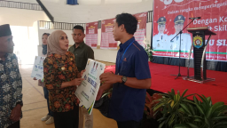 Keterangan: Bupati Tika, saat menyalurkan santunan BPJamsostek kepada salah satu pekerja di Kendal, usai membuka kegiatan Job Fair Kendal Tahun 2025, di Sport Center Kendal, Selasa 12/08/2025. (Roni/Jateng Memanggil)
