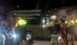 Petugas Satpol PP menggelandang seorang wanita ke arah mobil patroli saat menggerebek kawasan remang-remang di kawasan Kelapa Gading, Jakarta Utara, Senin (13/3/2023) malam. (Memanggil.co/Antara)