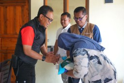 Kepala Diskominfo Garut, Margiyanto saat memberikan bantuan beras kepada salah seorang warga. (Memanggil.co/Wildan Fadilah)