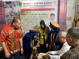 Dirjen Informasi dan Komunikasi Publik Kementrian Komunikasi  dan Informastika RI Usman Kansong mencoba langsung sensasi melinting kretek di stan Museum Kretek Kudus.