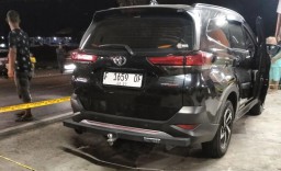 Personel Polsek Palabuhanratu memasang garis polisi di lokasi penemuan jasad Sekdis Perindustrian dan Perdagangan Kabupaten Sukabumi yang ditemukan di dalam mobil Toyota Rush yang sedang terparkir di kios Tahu Sumedang di Kampung Cileungsi, Desa Citarik, 