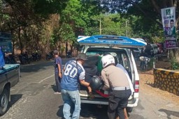Anggota Satlantas Polres Situbondo, jawa Timur, mengevakuasi Hokky Krisdianto dari lokasi kejadian kecelakaan, Senin (18/11/2024) (Memanggil.co/Antara)