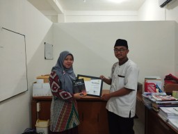 Yusron Ridho Nurfatoni saat menyerahkan buku pertamanya yang berjudul Cinta di Fakultas Tarbiyah kepada Ketua Program Studi PAI Siti Nurkayati (Memanggil.co/IAIKU Blora)
