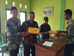 Kepala Desa Nglanjuk saat membagikan sarung kepada ulama dan warga desa, Jumat (28/3/2025) (Memanggil.co/Sobirin)