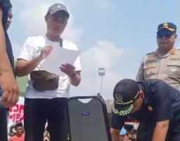 Ketua DPRD Blora, Mustopa ketika menandatangani tuntutan para pengunjuk rasa di Lapangan Kridosono Blora. (Memanggil.co)