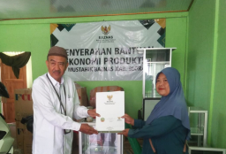 Ngasrini ketika menerima bantuan gerobak pentol, payung dan modal Rp 350 ribu dari Baznas Kabupaten Blora. (Memanggil.co/Ist)